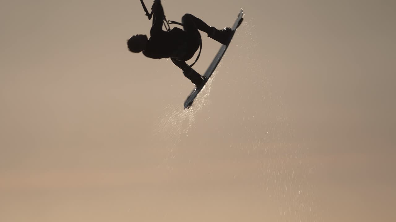 Kitesurfing silhuett ved solnedgang