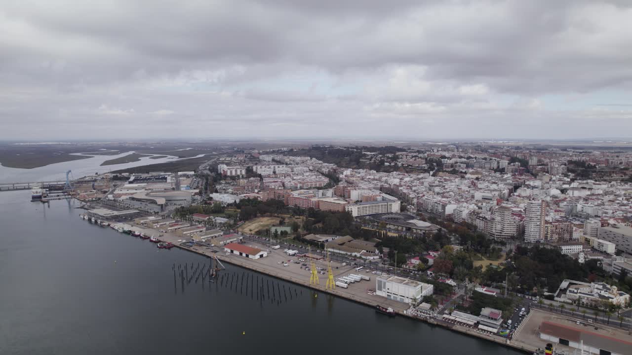 vuelo aéreo sobre el río odiel con vistas al puerto de la terminal logística de huelva y al paisaje urbano de fondo