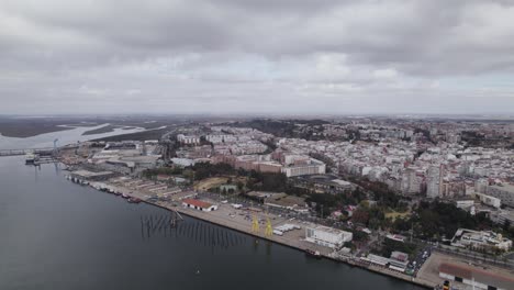 Vuelo-Aéreo-Sobre-El-Río-Odiel-Con-Vistas-Al-Puerto-De-La-Terminal-Logística-De-Huelva-Y-Al-Paisaje-Urbano-De-Fondo