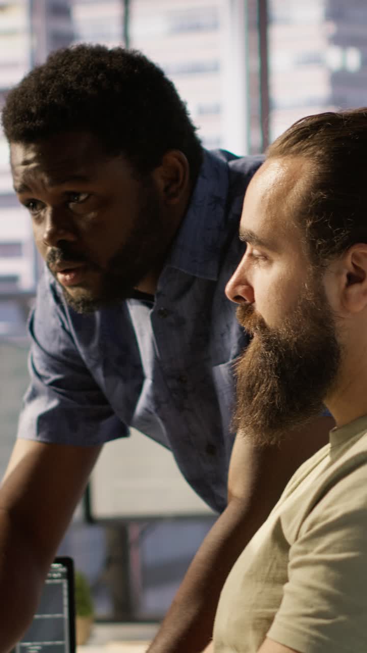 Vertical video Team leader supervising IT staff member optimizing code