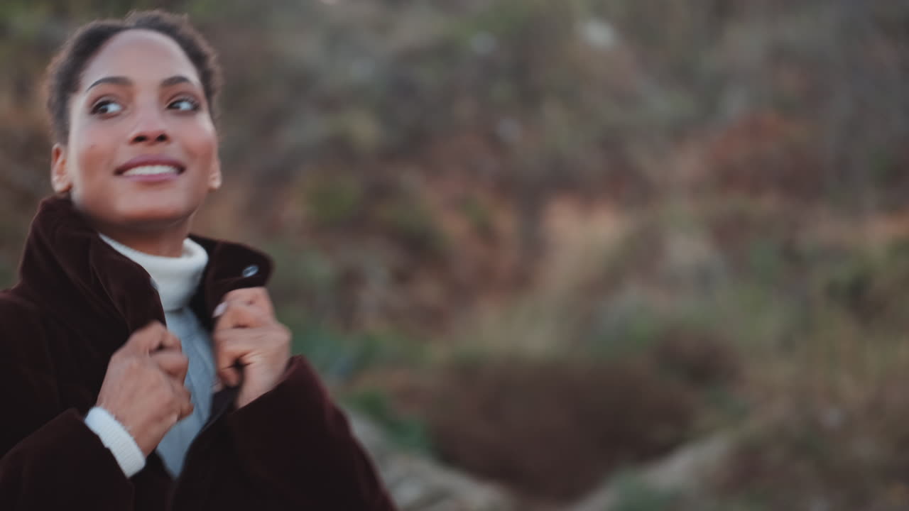 una chica afroamericana caminando felizmente al aire libre.