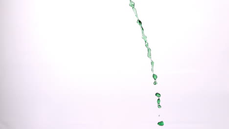 green water pouring across white background