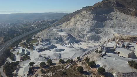 aerial descending view of a big quarry in a mountain