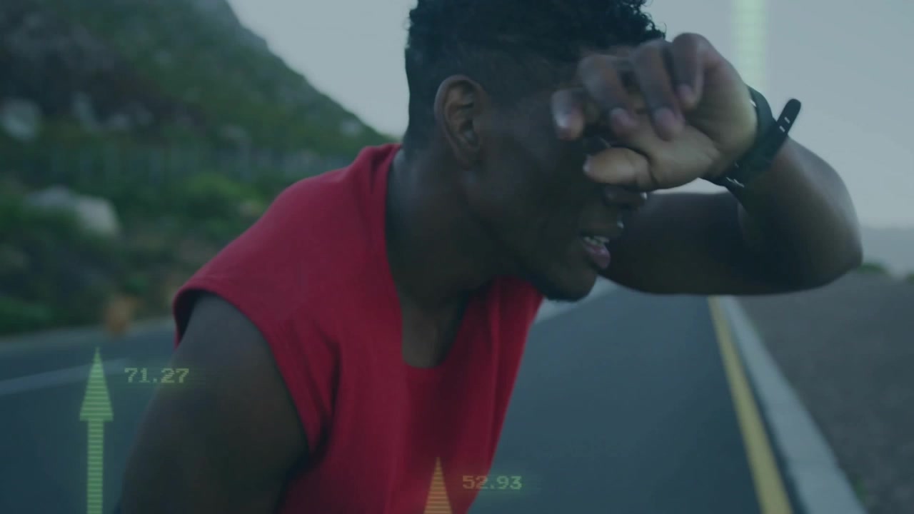 Male runner glancing at wrist device while monitoring AR fitness metrics tracking performance