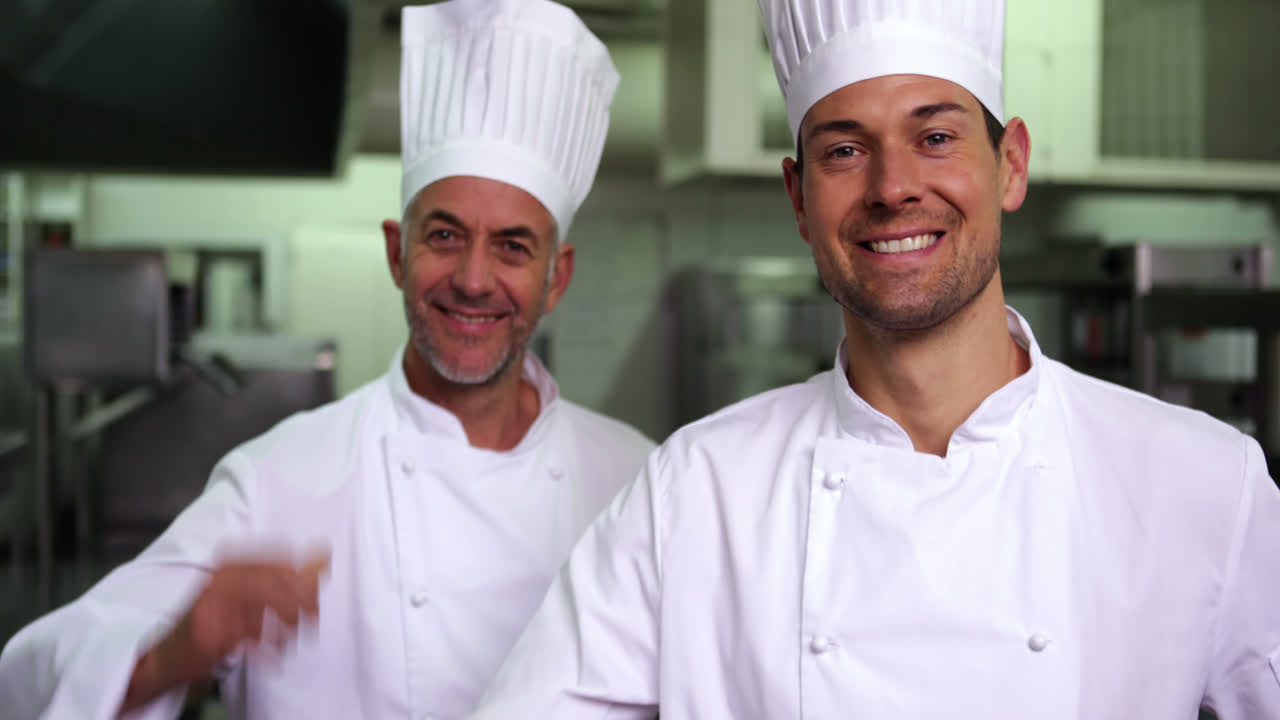 dos cocineros sonrientes dando el signo de ok a la cámara