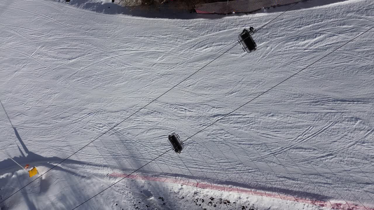 There are winter sports that play the role of the Winter Olympics in Cortina and Milano Italy. Learning to ski and snowboard I capture these videos with my drone that is in a ski resort. white color