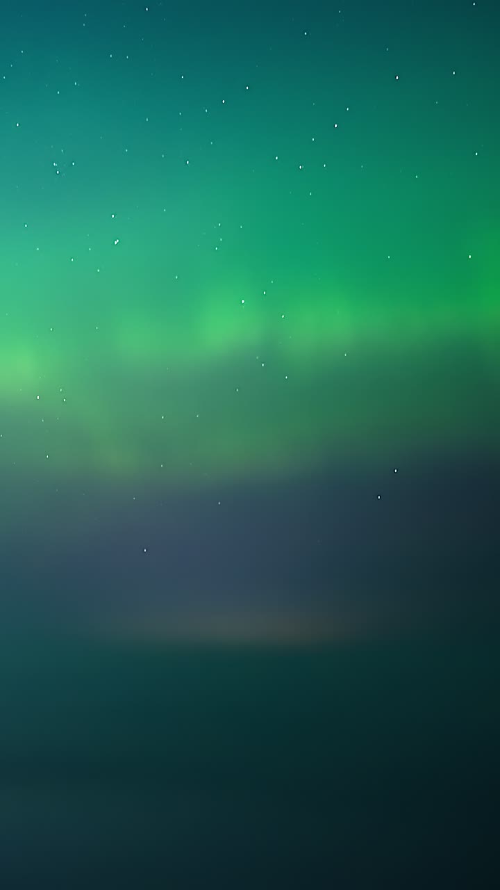 Aurora boreale verde e viola che brilla su un cielo scuro stellato sopra un paesaggio rurale - timelapse verticale cinematografico con drone.