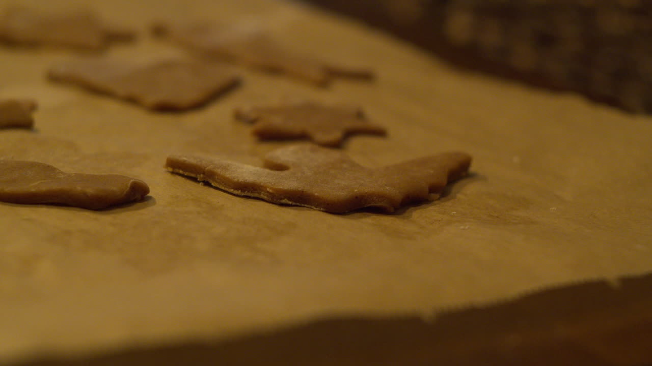 Colocando biscoitos de gengibre cortados em papel manteiga