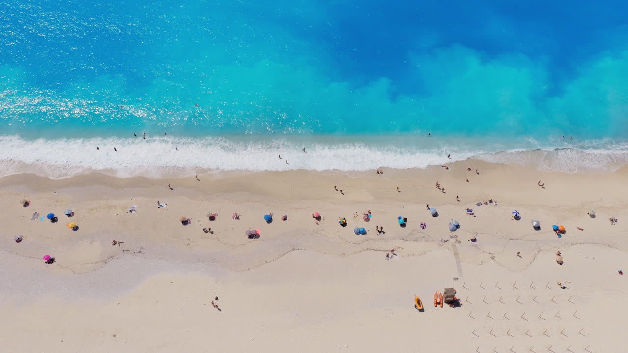 Tourists at Myrtos beach on Kefalonia island in Ionian sea, turquoise crystal clear water, Aerial view