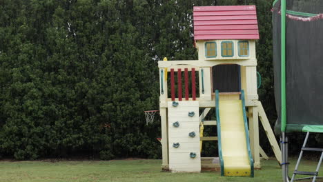 empty playground in a back yard next to a trampoline