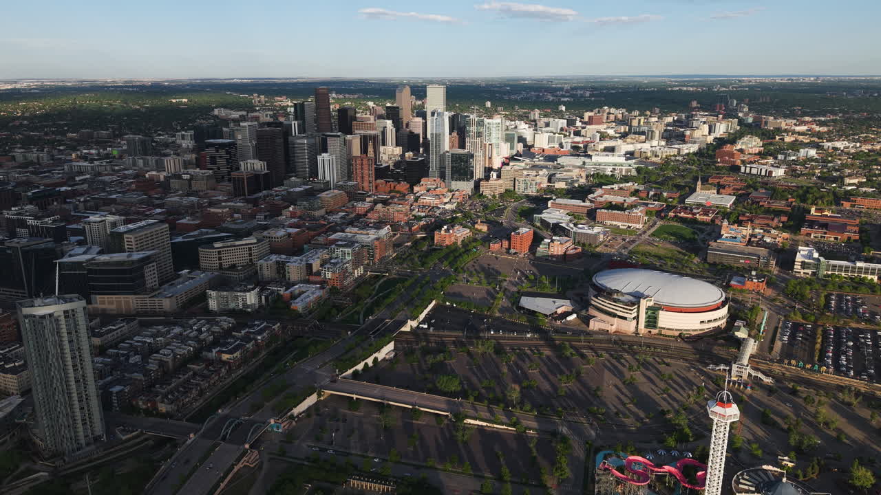 Establishing drone shot of approaching downtown Denver, golden hour in USA