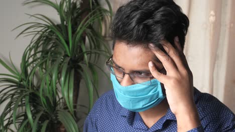 young man wearing mask and glasses looking stressed