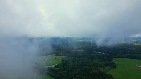 nubes de niebla cubren el verde campo de letonia desde un drone aéreo filmado en europa