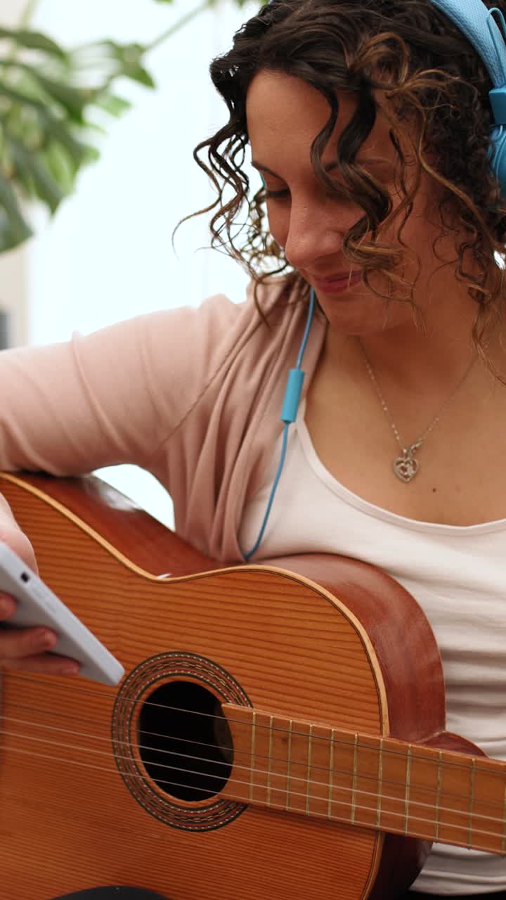 Musician reading music on smartphone while holding acoustic guitar
