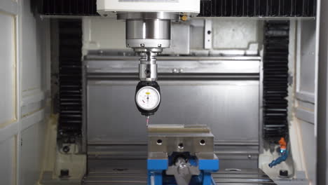 cnc machine 3d taster dial indicator measuring a steel part in a vice