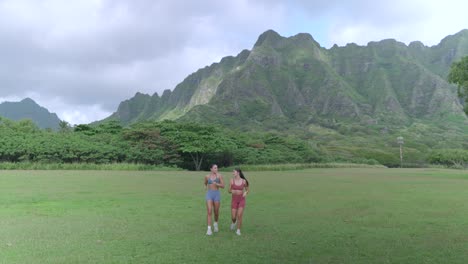 two fitness models running into frame, walking towards camera