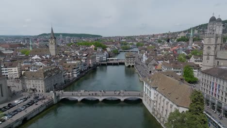 Slow-forward-moving-panning-drone-showing-city-inhabitants,-the-cathedral,-public-transport-and-skyline