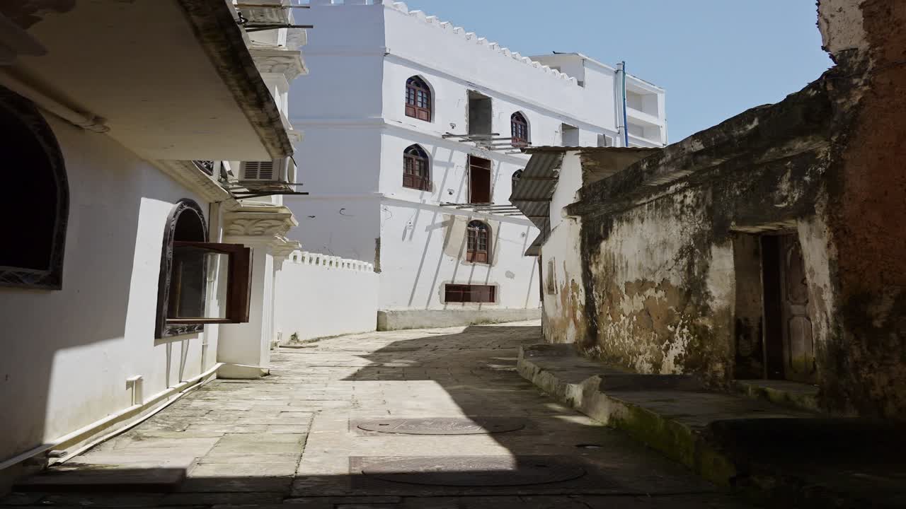 zanzíbar viejos edificios en stone town, video vertical para redes sociales, reels de instagram y tiktok de pequeñas calles laterales estrechas en la ciudad principal de zanzibar con antiguas ruinas de edificios en tanzania