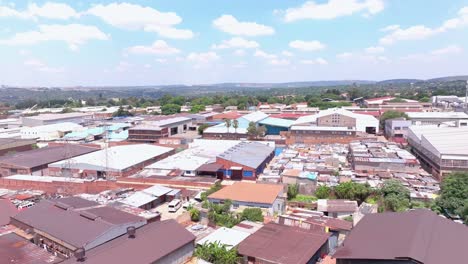 Aerial pan shot in an industrial area with informal settlement in Alexandra Township, Johannesburg, South Africa, on a sunny day with scattered clouds