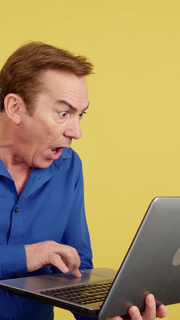 Man with surprised or shocked expression looking at a laptop