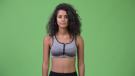 young beautiful hispanic woman with arms crossed ready for gym