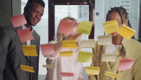 teamwork and brainstorming in in office of big company portrait of workers through post-it notes