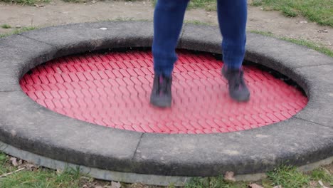 Persona-Saltando-Sobre-Un-Trampolín-De-Plástico-Rojo-Al-Aire-Libre