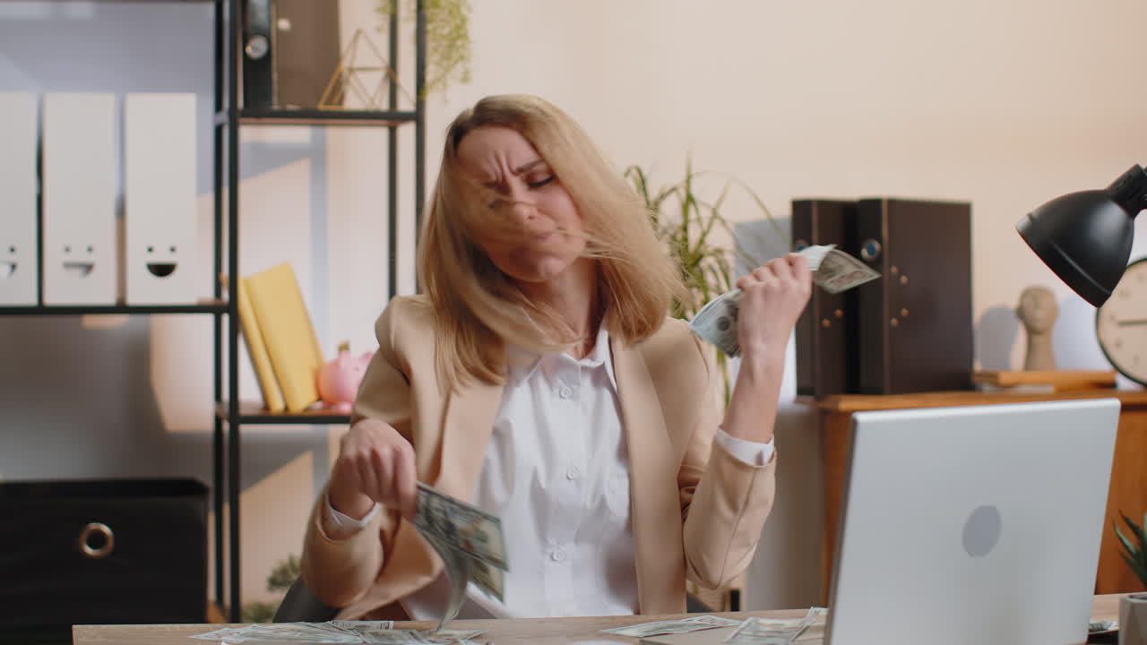 Young businesswoman winner holding fan of dollar money cash celebrate dance success career salary