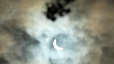 rack focus from bundle of flowers to lunar eclipse, partially obscured by clouds