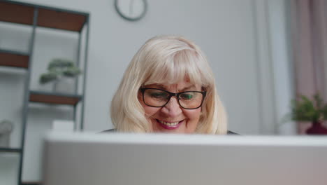 Una-Mujer-De-Negocios-Senior-Usa-Gafas-Trabajando-En-La-Oficina-Del-Hogar,-Seminario-Web-En-Línea-Usando-Una-Computadora-Portátil