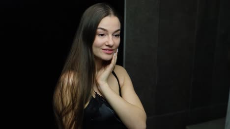 Attractive-Young-woman-looking-at-herself-in-the-bathroom-mirror