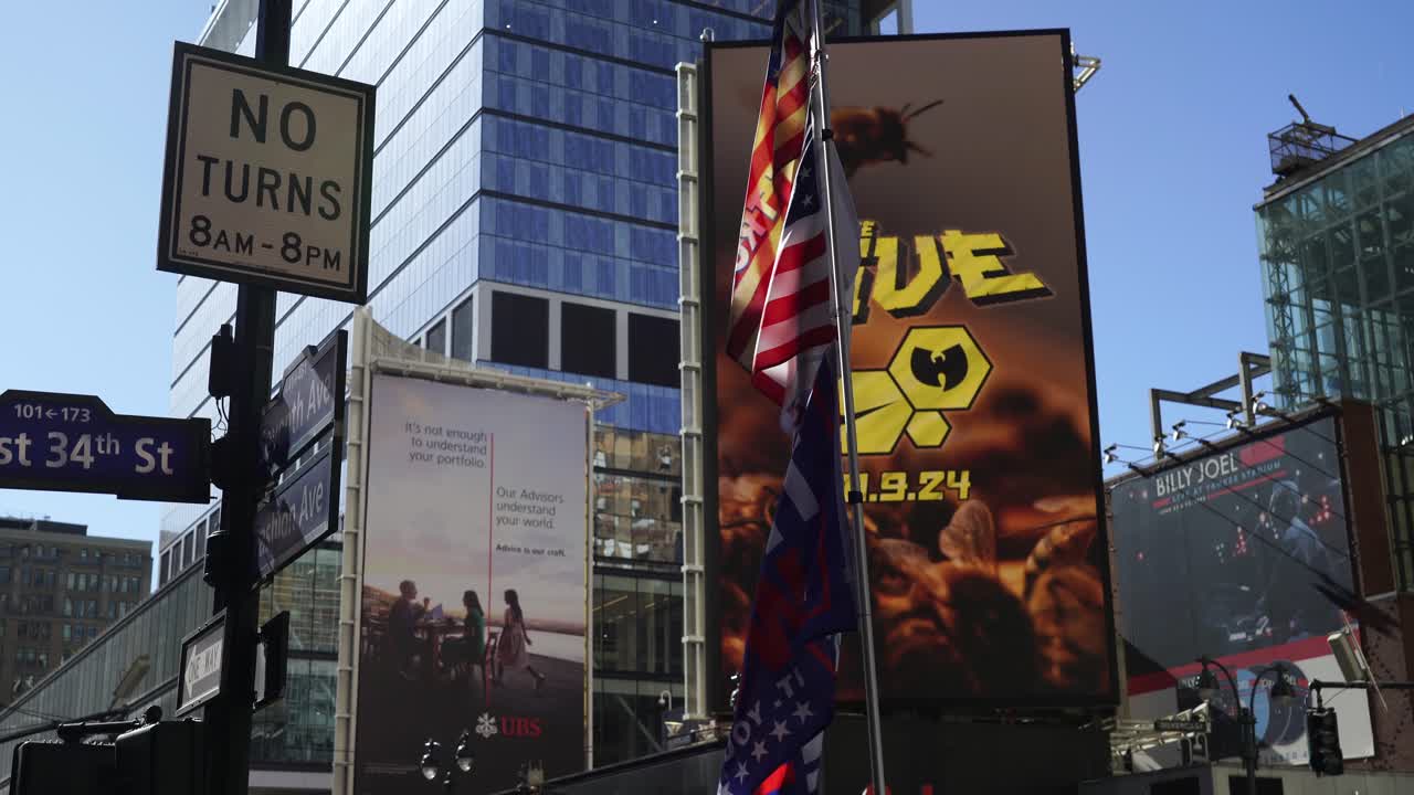 In the warm daylight, a Trump flag ripples in the breeze, its vibrant colors contrasting with the cityscape in the background