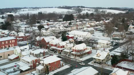 descending aerial on small american town covered in winter snow