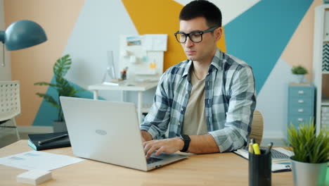 hombre trabajando en una computadora portátil en una oficina moderna