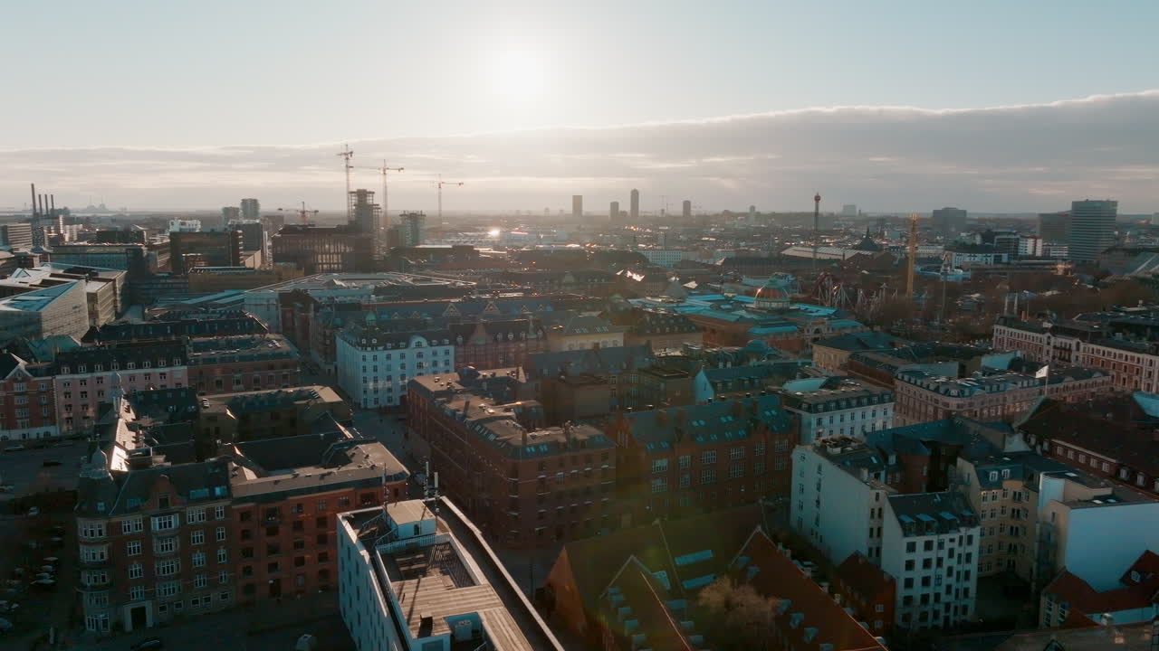 Pohyblivý záběr dronem na panorama centra Kodaně s projíždějícími auty a stavebními jeřáby v pozadí