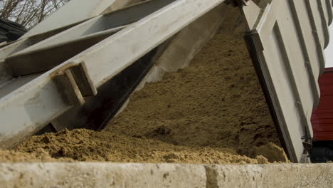 un camión que descarga el grano gastado de la cervecería en un contenedor