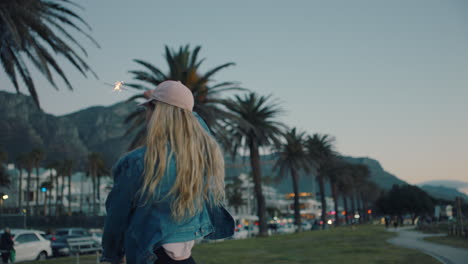 happy-teenage-girl-with-sparklers-dancing-on-beach-at-sunset-celebrating-new-years-eve-having-fun-independence-day-celebration-with-fireworks-enjoying-freedom