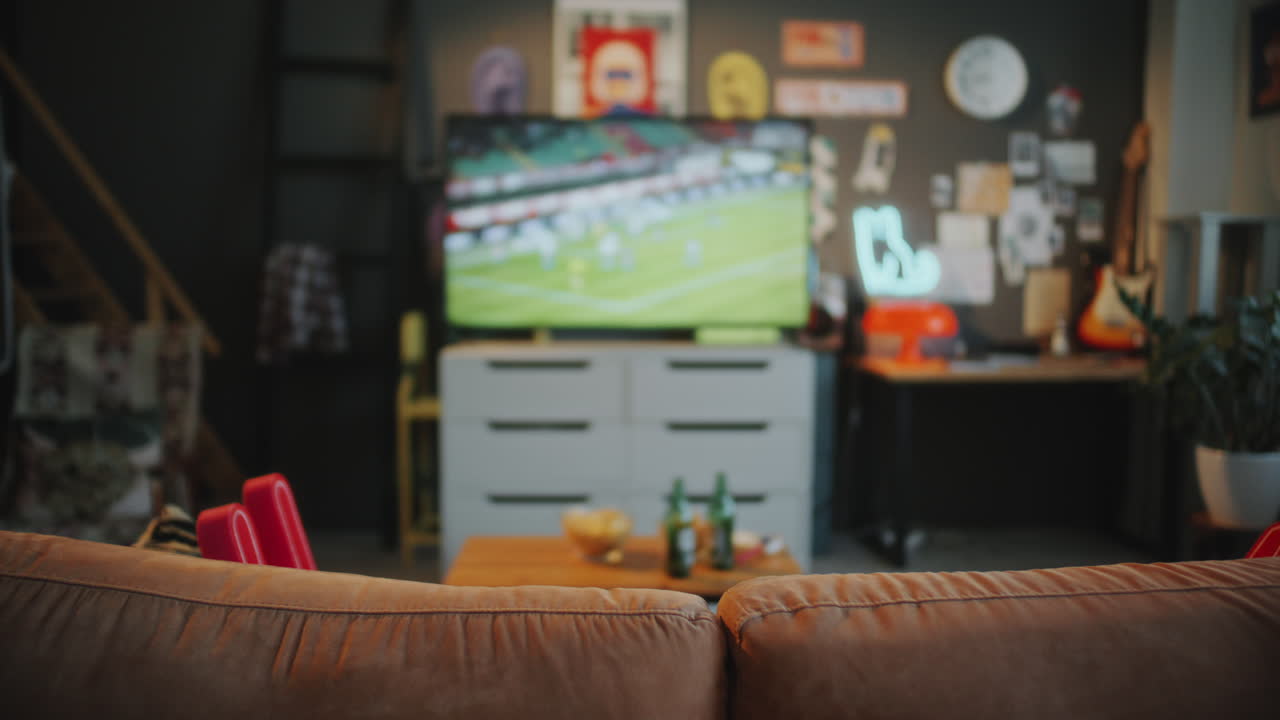 Empty Living Room with Soccer Match Playing on TV, Drinks and Snacks on Table