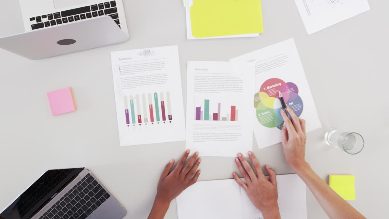 escritorio y manos en una reunión de negocios, zoom hacia fuera por encima