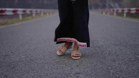person walking on an asphalt road in traditional attire