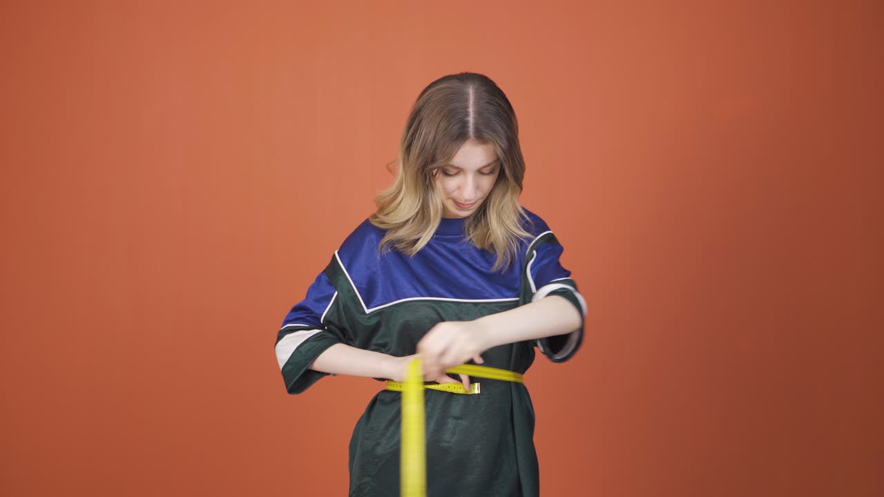 자신의 몸무게에 만족하는 젊은 여성.