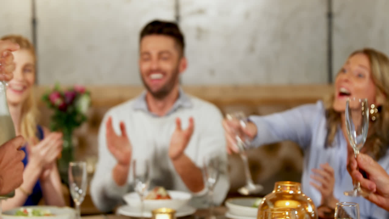 Uomo che serve champagne ai suoi amici a tavola 4K