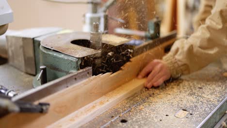 capenter grinding wooden planks on the old machine