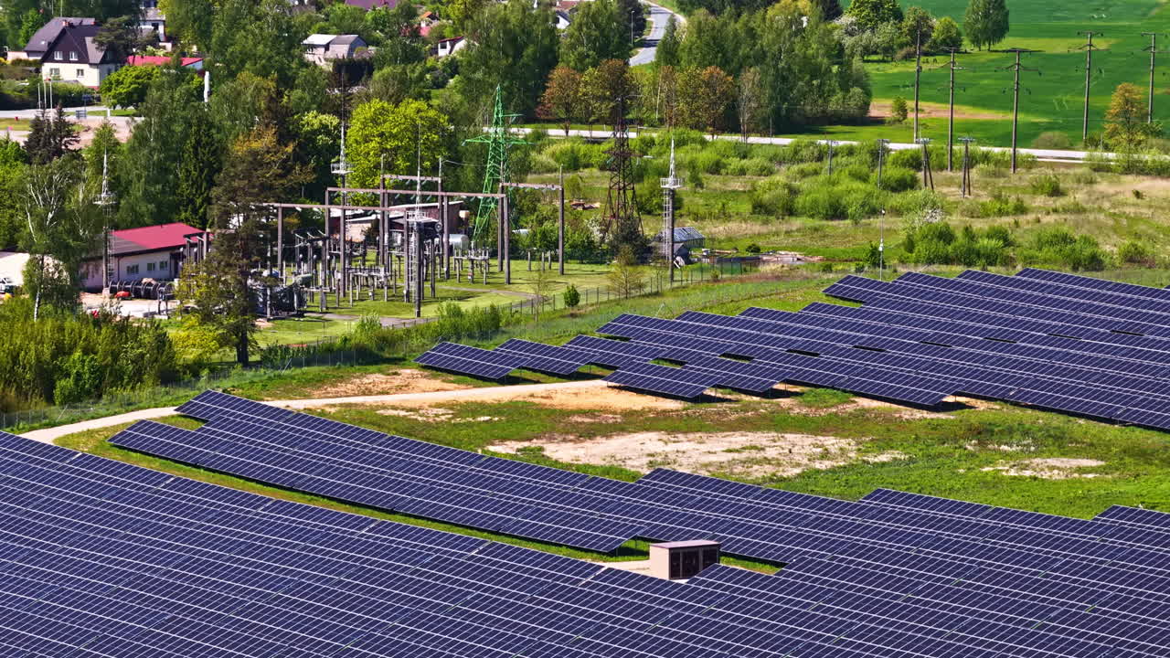 Huge solar panel farm near small village, aerial view