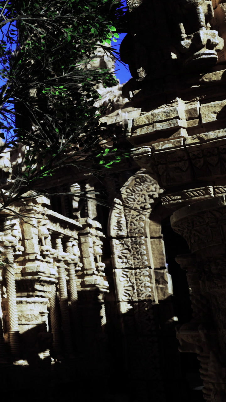 Ancient stone structure with detailed carvings and blue sky above
