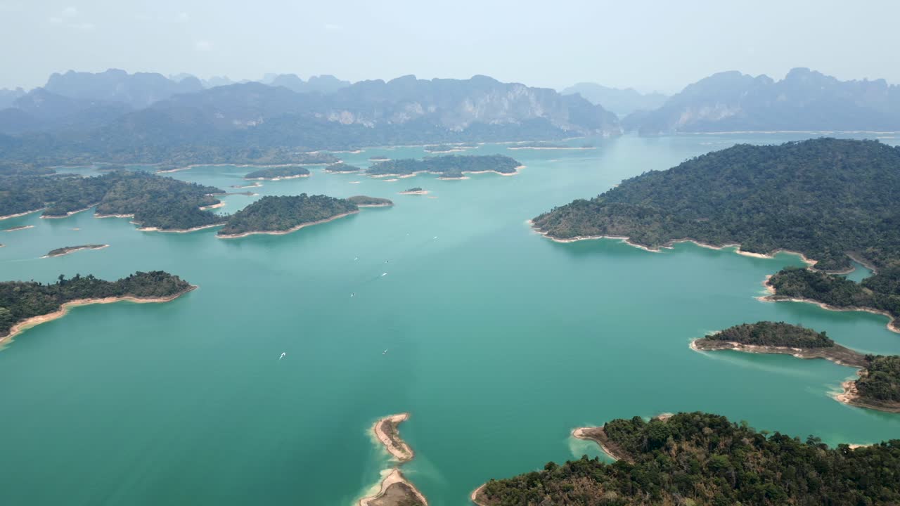 Aerial view of a stunning turquoise lake dotted with lush islands and surrounded by mountains