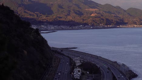 Slow-tilt-up-over-car-traffic-on-highway-in-Japan-with-snowy-Mt