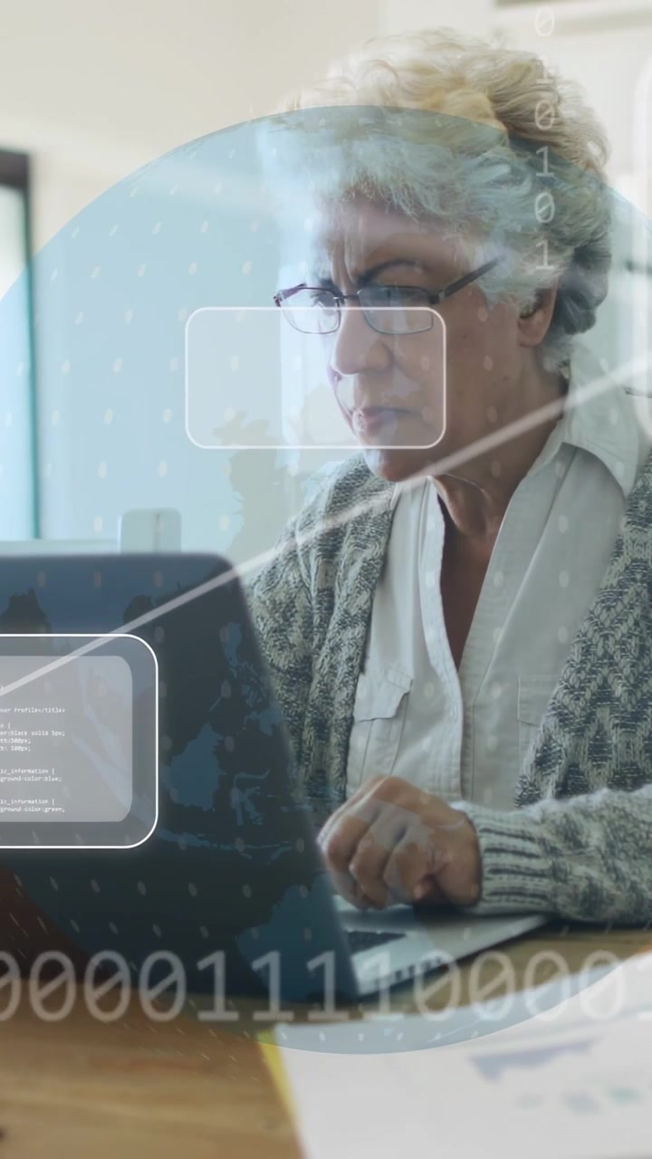 Vertikal video: Ældre kvinde taster på pc ved skrivebord, tilgår online data, der viser tech UI globusikoner