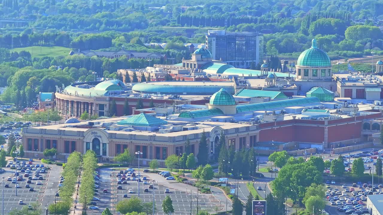 Jib up drone shot of Trafford Centre large indoor shopping centre and entertainment complex in Trafford Park, Greater Manchester, England