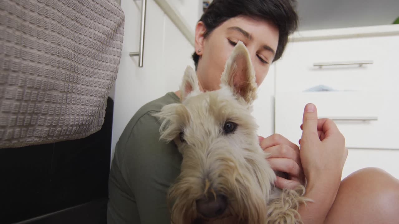 집에서 부 ⁇ 에 앉아있는 개와 키스하는 백인 여성